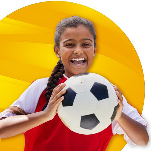 Girl with a soccer ball in her hands smiling. Yellow textured circle in background.
